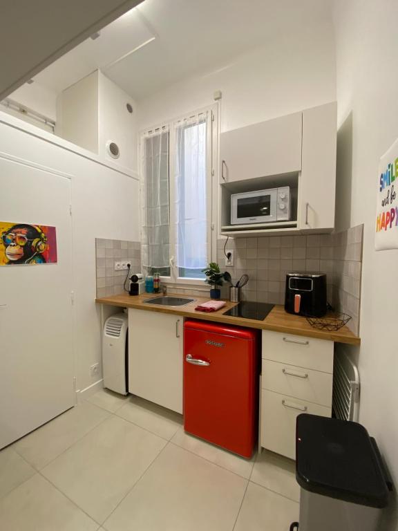 La cuisine est équipée d'un réfrigérateur rouge et d'un four micro-ondes. dans l'établissement Studio Garibaldi, à Nice