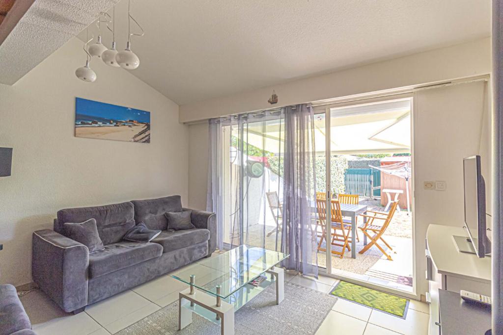 un salon avec un canapé et une table en verre dans l'établissement Appart 3 pièces, à Capbreton