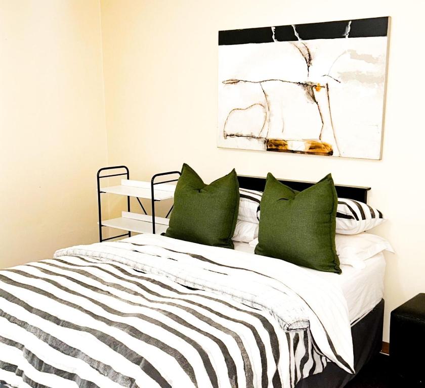 a bedroom with a bed with green pillows at AK Secunda Accommodation in Secunda