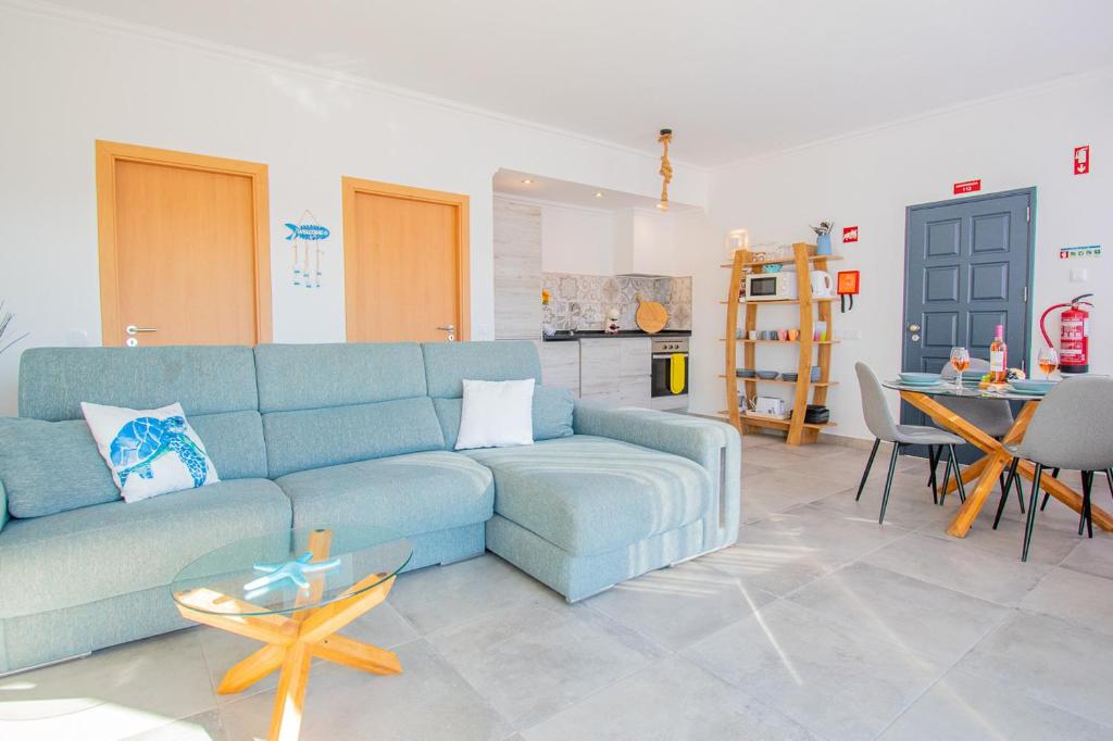 ein Wohnzimmer mit einem blauen Sofa und einem Tisch in der Unterkunft Kizi Lovely apartment in Poço Partido