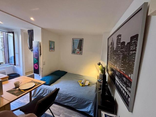 une chambre avec un lit et une table dans une pièce dans l'établissement Le Petit Sphynx - 9m2, à Vichy