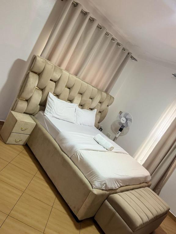 a large bed in a room with a window at KOSUHOMEs in Namugongo