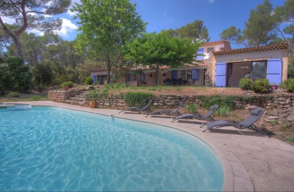 une piscine avec des chaises et une maison dans l'établissement Villa Martine, authentic family home, à Rognes