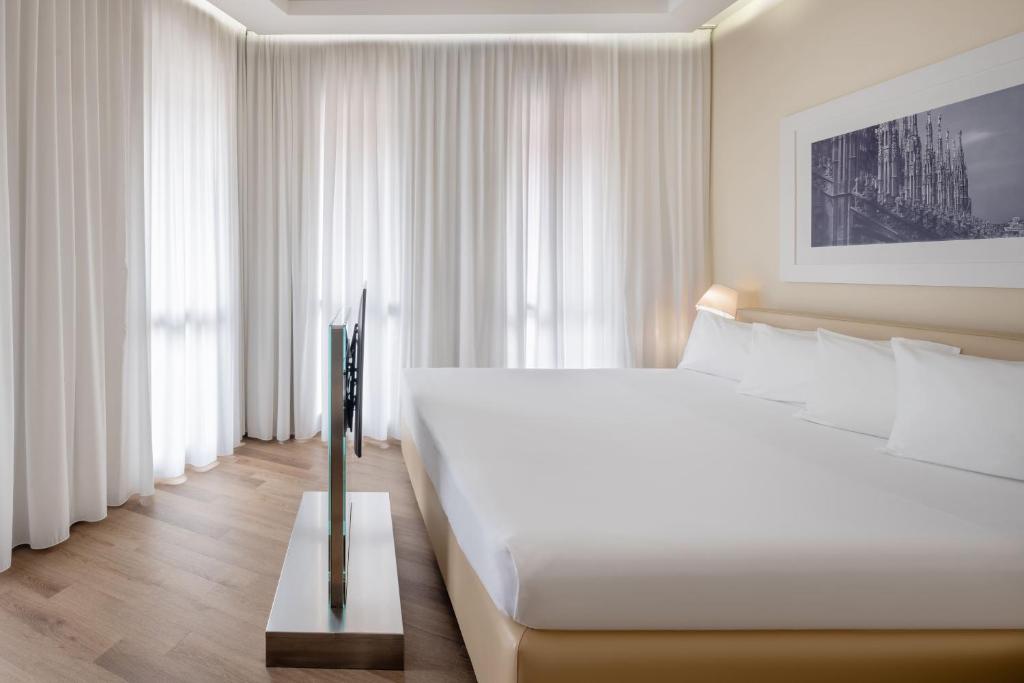 Postel nebo postele na pokoji v ubytování UNA HOTELS Cusani Milano