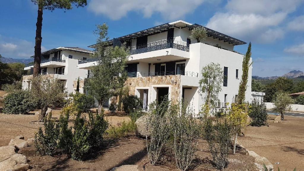 une grande maison blanche avec des arbres devant dans l'établissement T3 Tout confort à 5 mn des plages de Pinarello, à Pinarellu