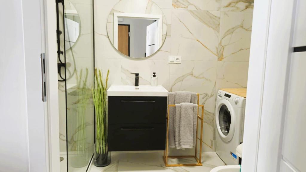 a bathroom with a sink and a mirror at Elite Home 5 Jeżyce- Barańczaka 5 in Poznań