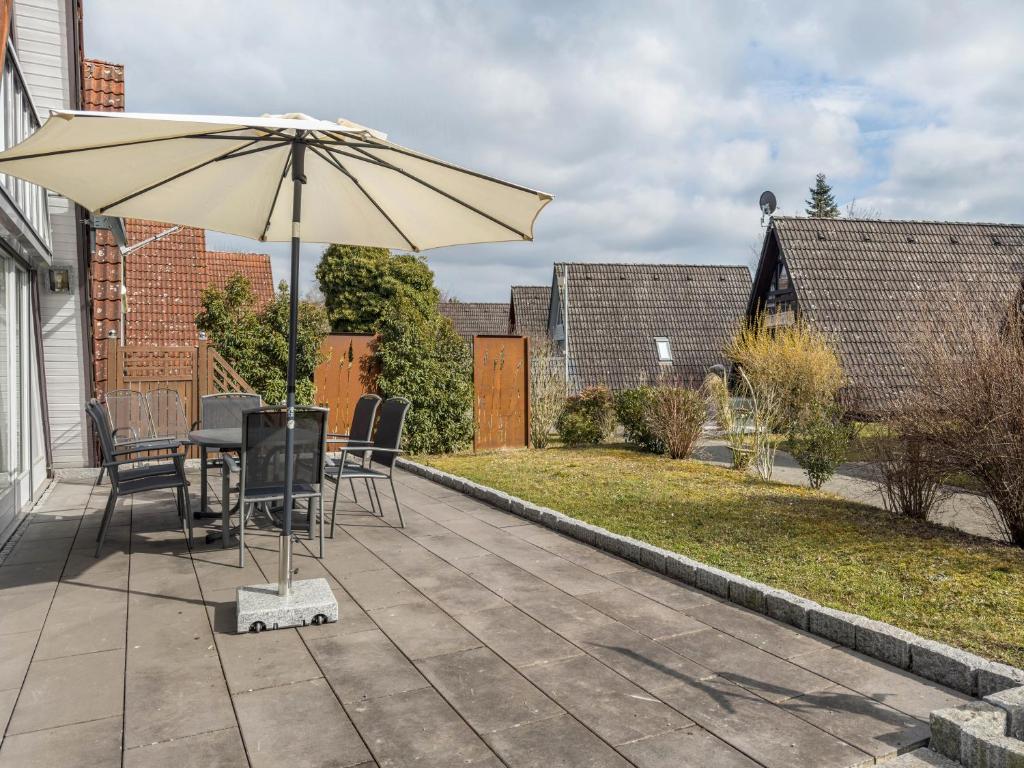 a patio with a table and an umbrella at Wikinger 74 in Immenstaad am Bodensee