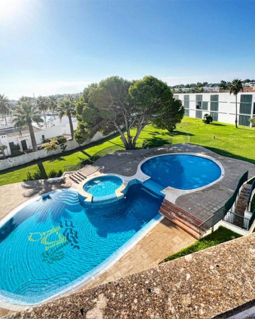 an overhead view of a large swimming pool with chairs around it at Casa Binimel-là con piscina a Cala n'Bosh Menorca in Cala en Bosc