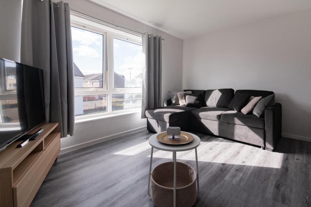 un soggiorno con un divano e una TV di Renfrew House a Renfrew