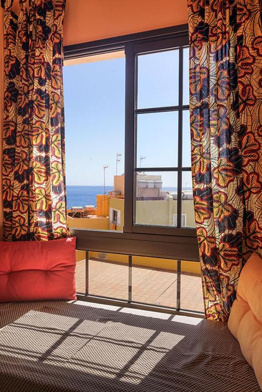 a room with a window with a view of the ocean at Große Dachwohnung mit Blick auf das Meer in Valle Gran Rey