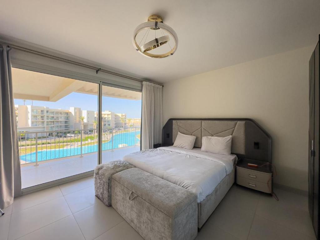 a bedroom with a bed and a large window at Lagoon chalet in marina views 3 bedrooms perfect view exm68 in El Alamein