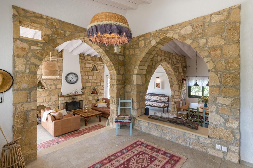 a living room with a large stone wall at Villa Nomi in Peyia