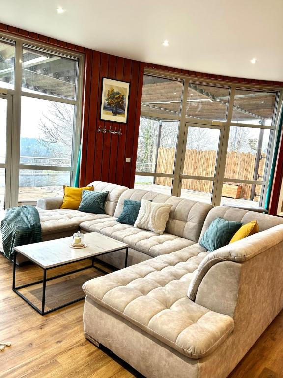 - un salon avec un grand canapé et une table dans l'établissement Location gîte atypique Jura, à Lons-le-Saunier