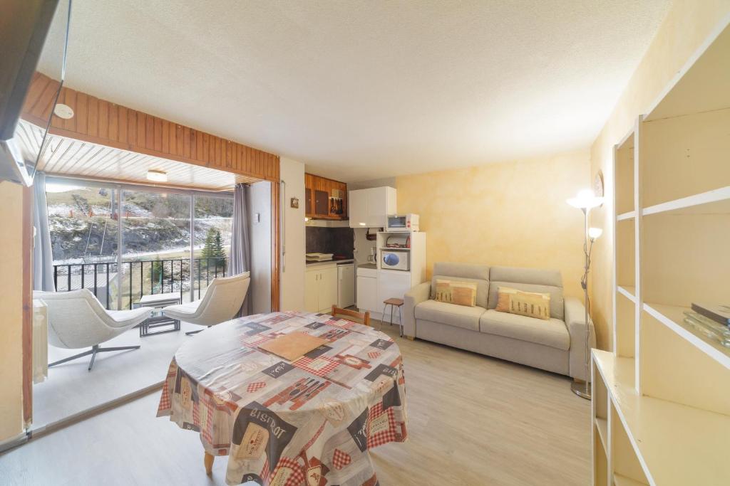a living room with a couch and a table in a room at Le Nid de Gourette - Au Pied des Pistes in Eaux-Bonnes