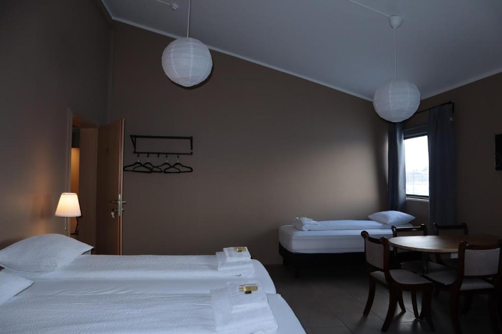 Una habitación de hotel con dos camas y una mesa y sillas. en Blue Viking Studios, en Keflavík