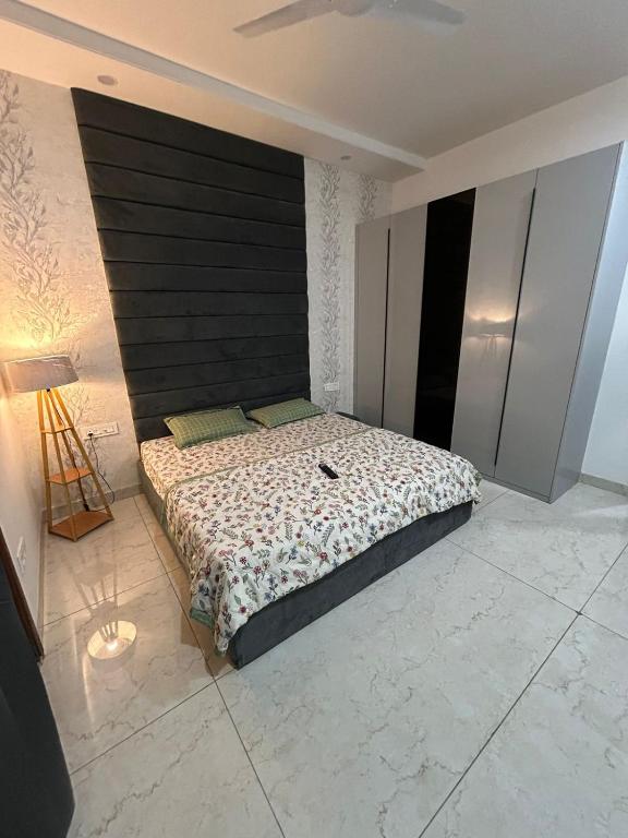 a bedroom with a large bed with a black headboard at Aerogreen Homestays in Zirakpur