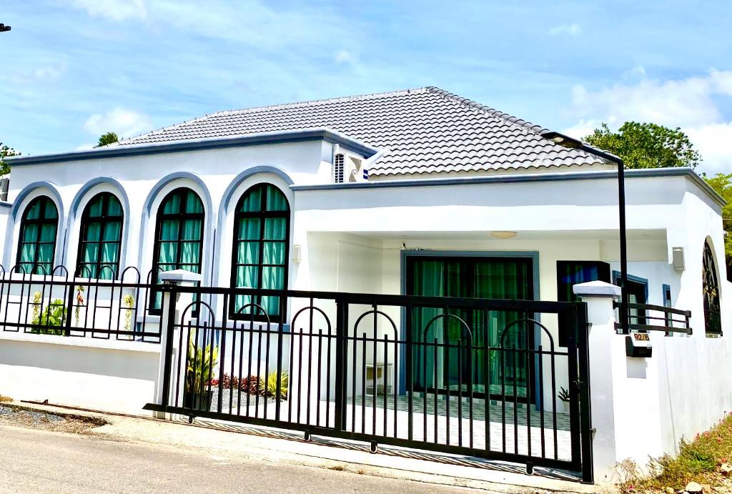 ein weißes Haus mit einem schwarzen Zaun in der Unterkunft Le Trang Boutique Airport in Trang
