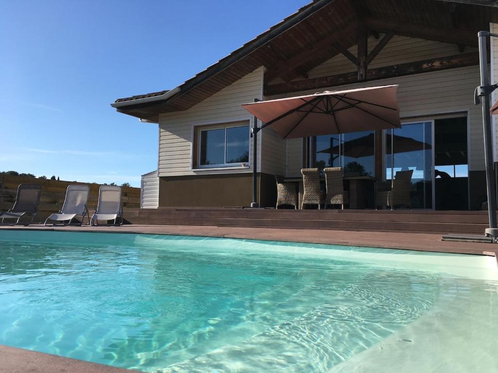 une maison dotée d'une piscine avec des chaises et un parasol dans l'établissement Villa Ita 6 to 8 berths - Private pool, à Moliets-et-Maa