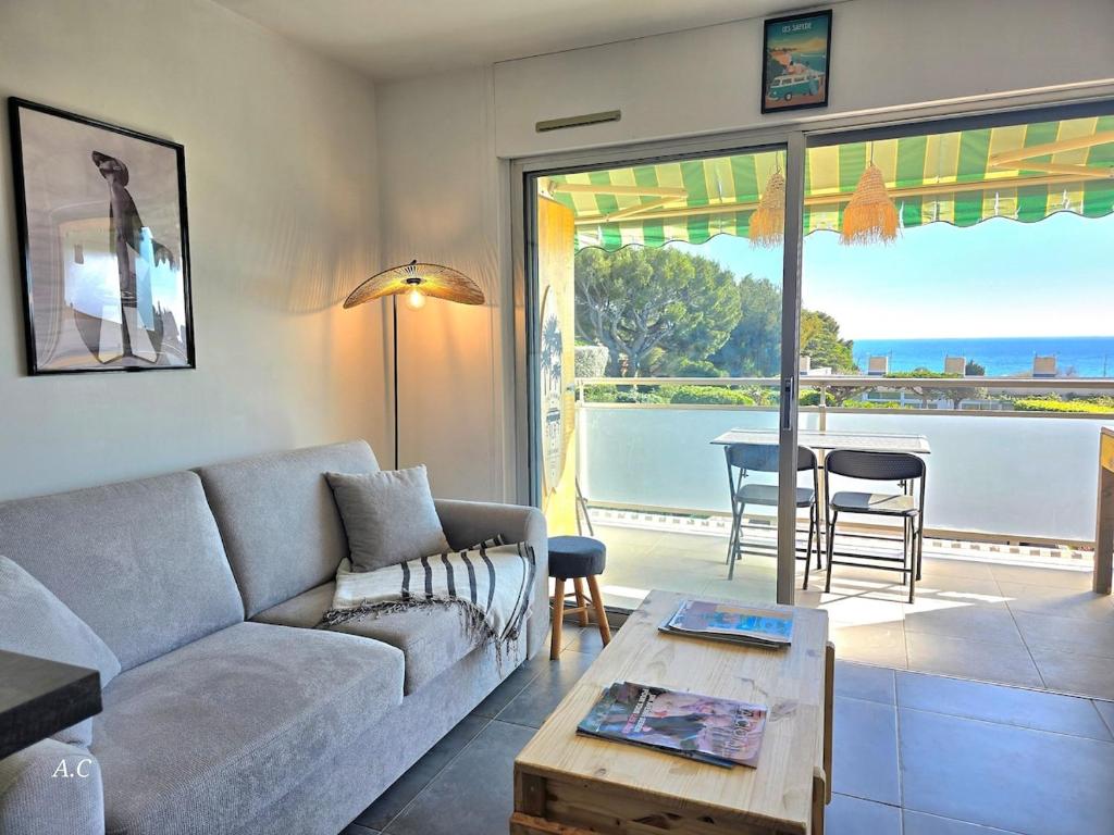 un salon avec un canapé et une table dans l'établissement La Baie - Studio neuf avec balcon vue mer, à 5min de la mer avec parking - By AURAconciergerie, à La Ciotat