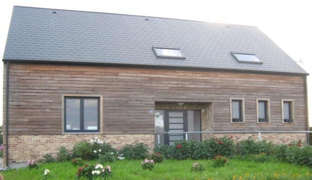 a brick house with windows and a grass yard at Au Coeur des Champs in Regniowez