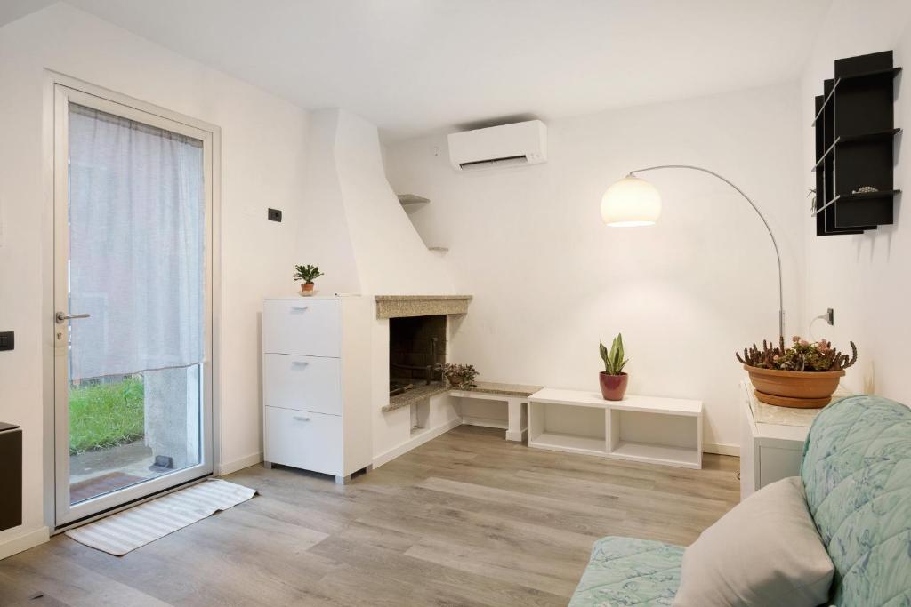 a white living room with a fireplace and a couch at Gli Ulivi in Santo Stefano di Magra