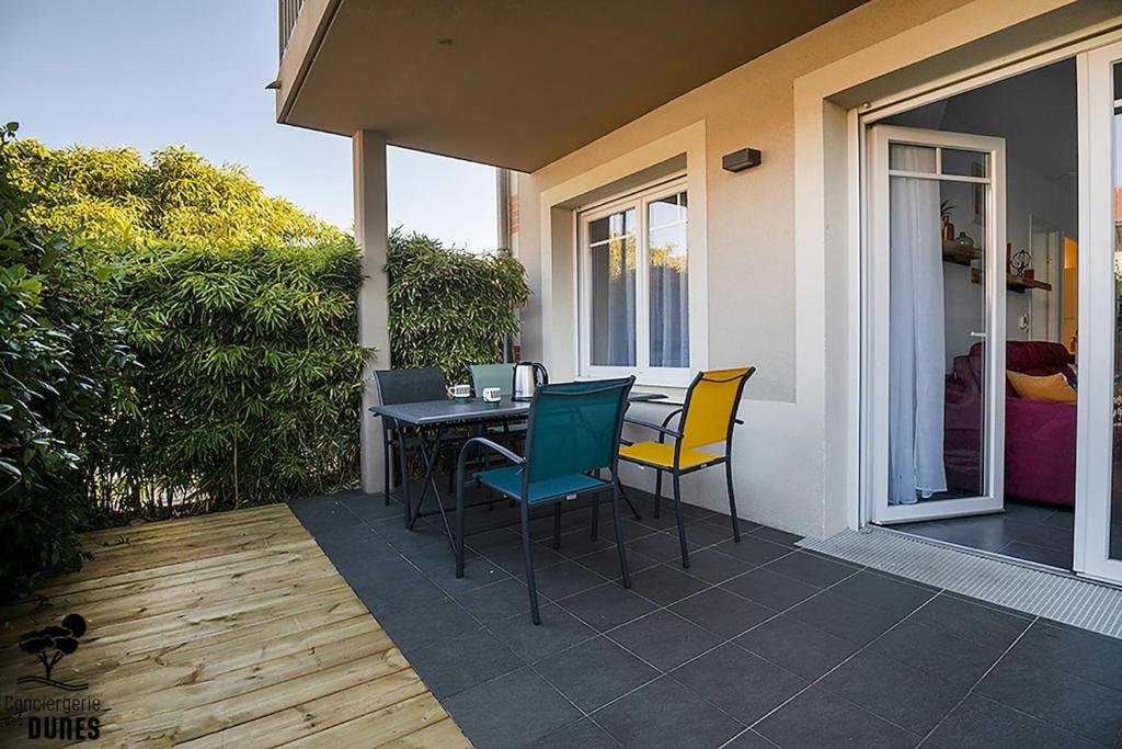 un patio avec une table et des chaises sur un porche dans l'établissement Great Studio, à Arcachon