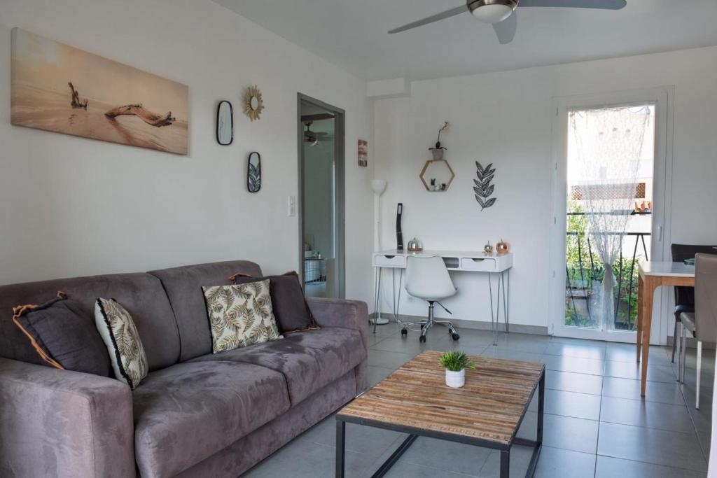 un salon avec un canapé et une table dans l'établissement Beautiful T3 with balcony near downtown, à Sainte-Maxime