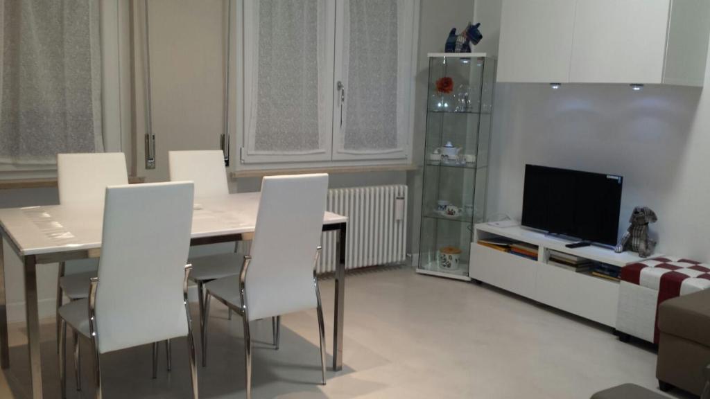 a living room with a table and white chairs at Bed & Breakfast Sforza 19 in San Colombano al Lambro