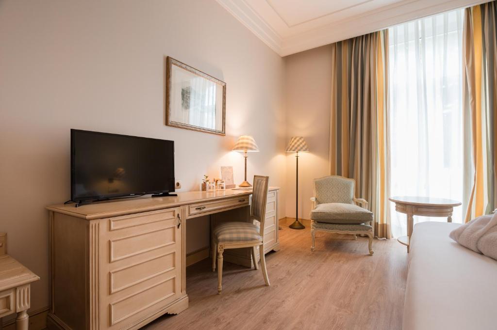 a hotel room with a desk with a flat screen tv at Castilla Termal Solares in Solares