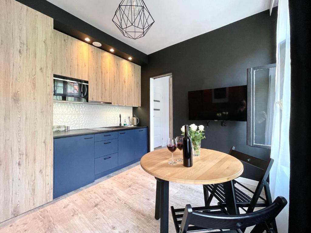 a kitchen with a table with wine glasses on it at Copernicus Street Apartment - Broken Flowers and Twin Peaks in Toruń