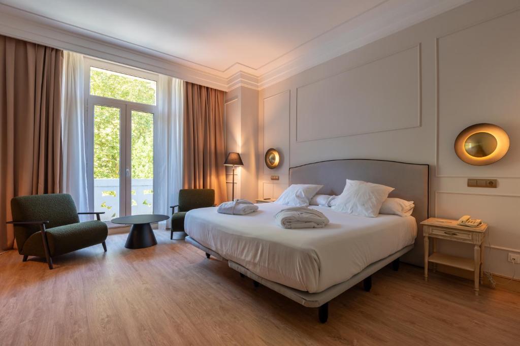 a hotel room with a bed and a large window at Castilla Termal Solares in Solares