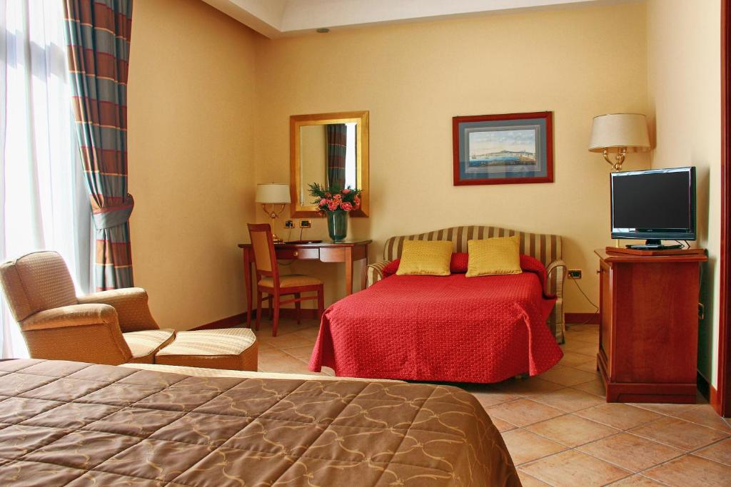 pokój hotelowy z łóżkiem i telewizorem w obiekcie Le Cheminée Business Hotel Napoli w mieście Napoli