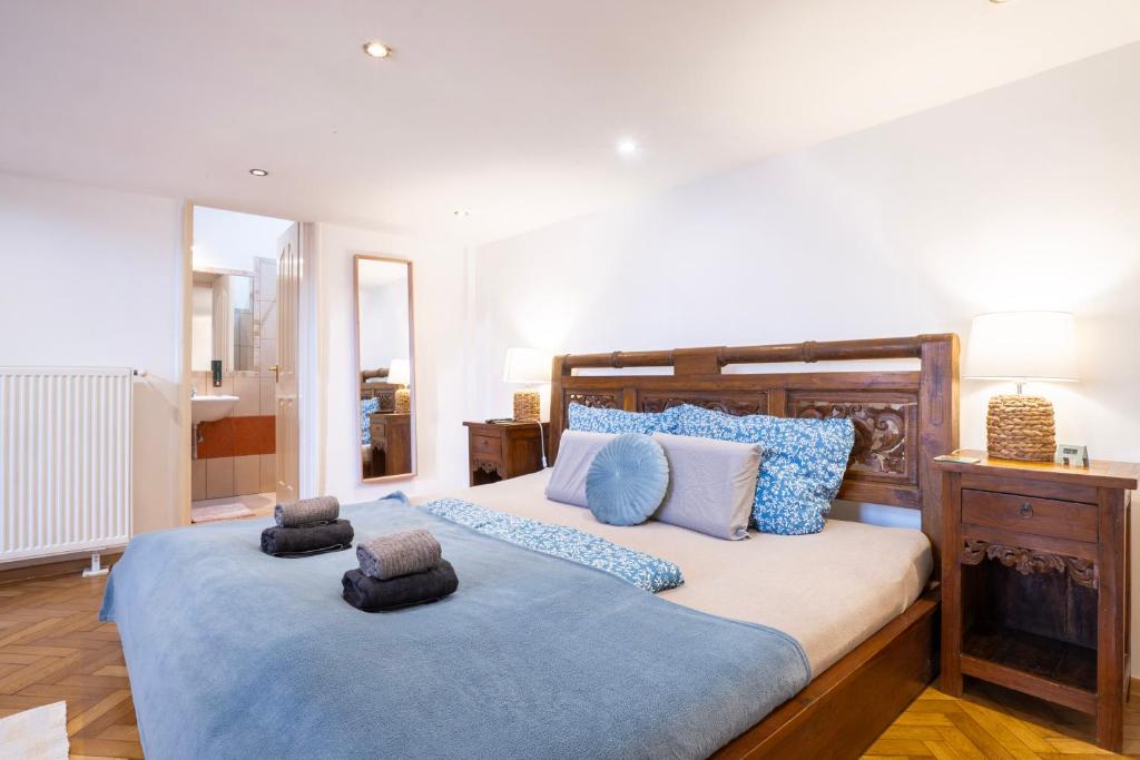 a bedroom with a large bed with blue pillows at Cedar Inn Budapest - Palace District in Budapest
