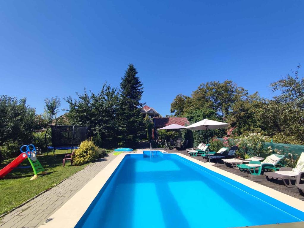 a swimming pool with a slide in a yard at Apartments in Balatonföldvar 45318 in Balatonföldvár