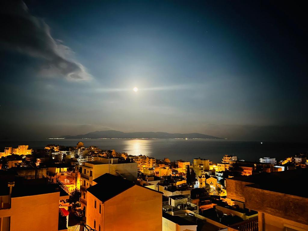 a view of a city at night with the moon at eliTe deluxe 4 skyview in Kavála