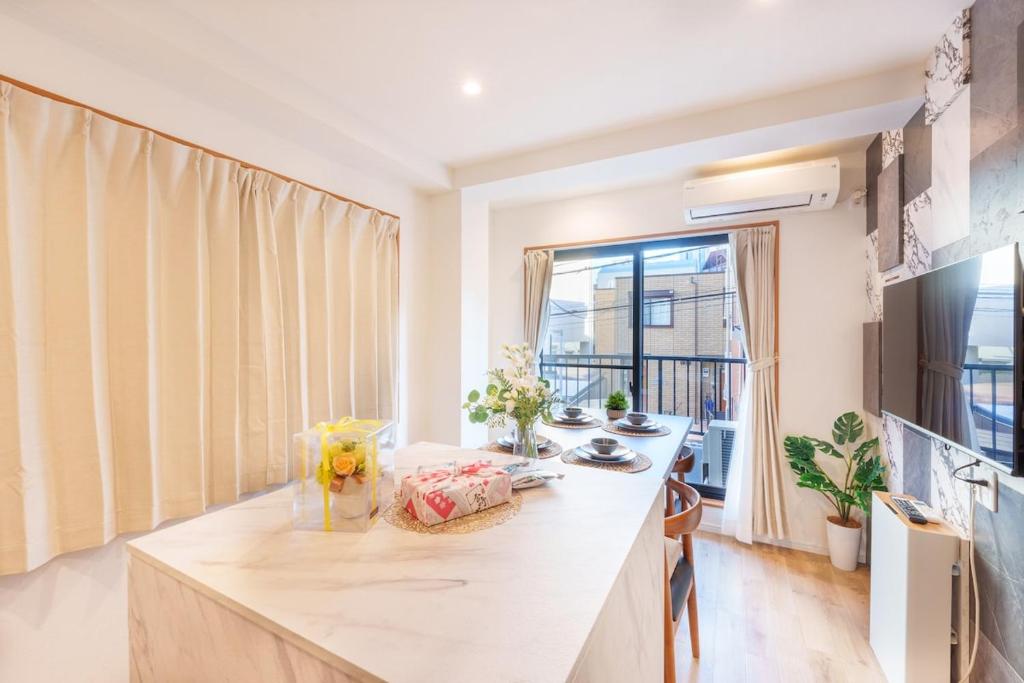 eine Küche mit einem Tisch und einem großen Fenster in der Unterkunft MINE HOME野方 121t in Tokio