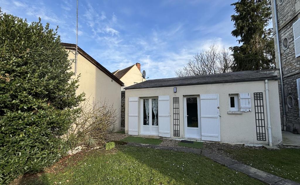 une petite maison blanche avec une cour dans l'établissement Maisonnette de Senlis, à Senlis