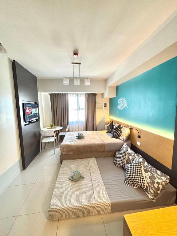 a bedroom with two beds and a blue wall at Horizons 101 Fab Condotel in Cebu City