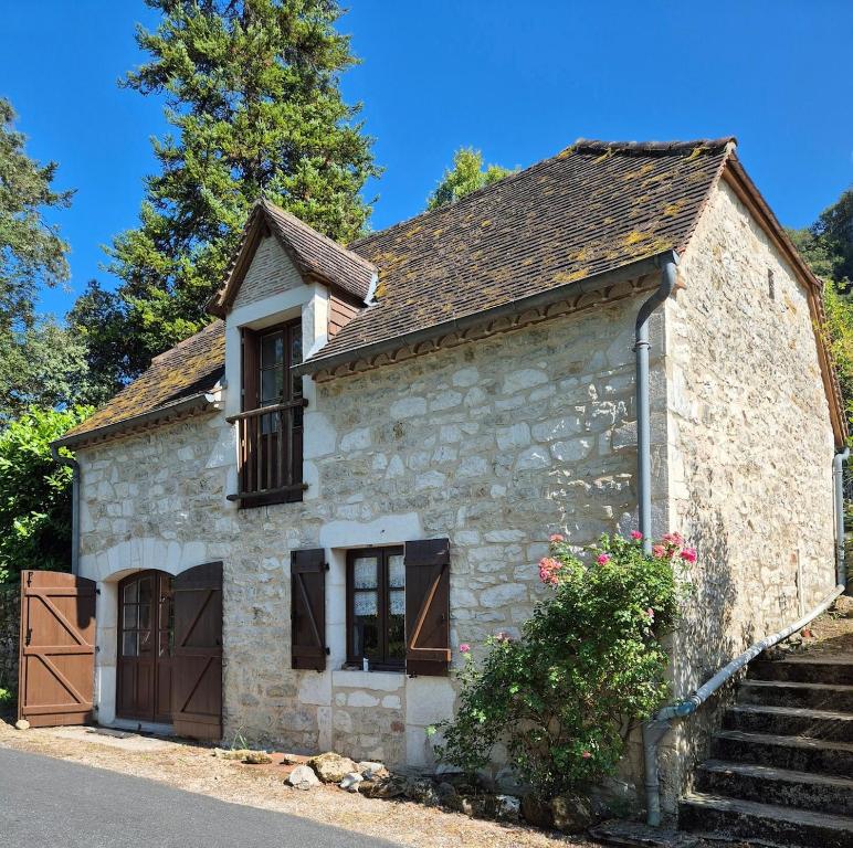 an old stone house with a window and stairs at La maison du bord de l'eau in Vayrac