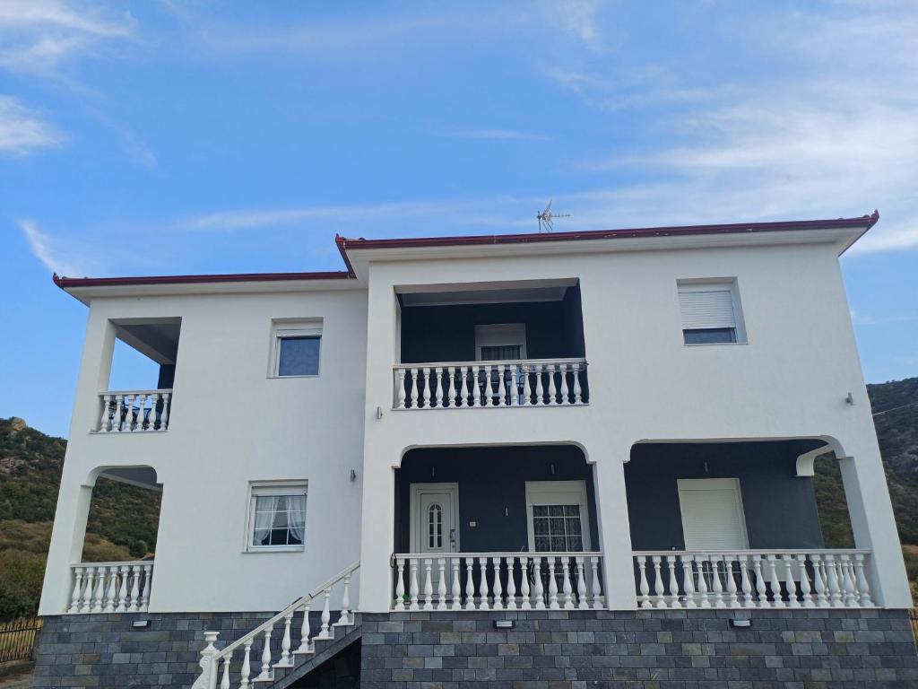 a white house with a balcony at Summer Paradise in Paralia Sikias