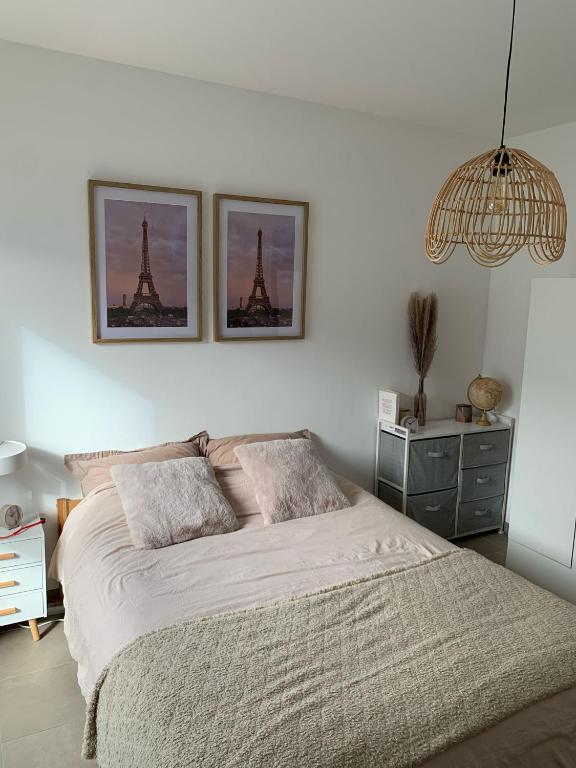 une chambre avec un lit avec deux tableaux au mur dans l'établissement Auberge Chambre La Bienveillance, à Lormont