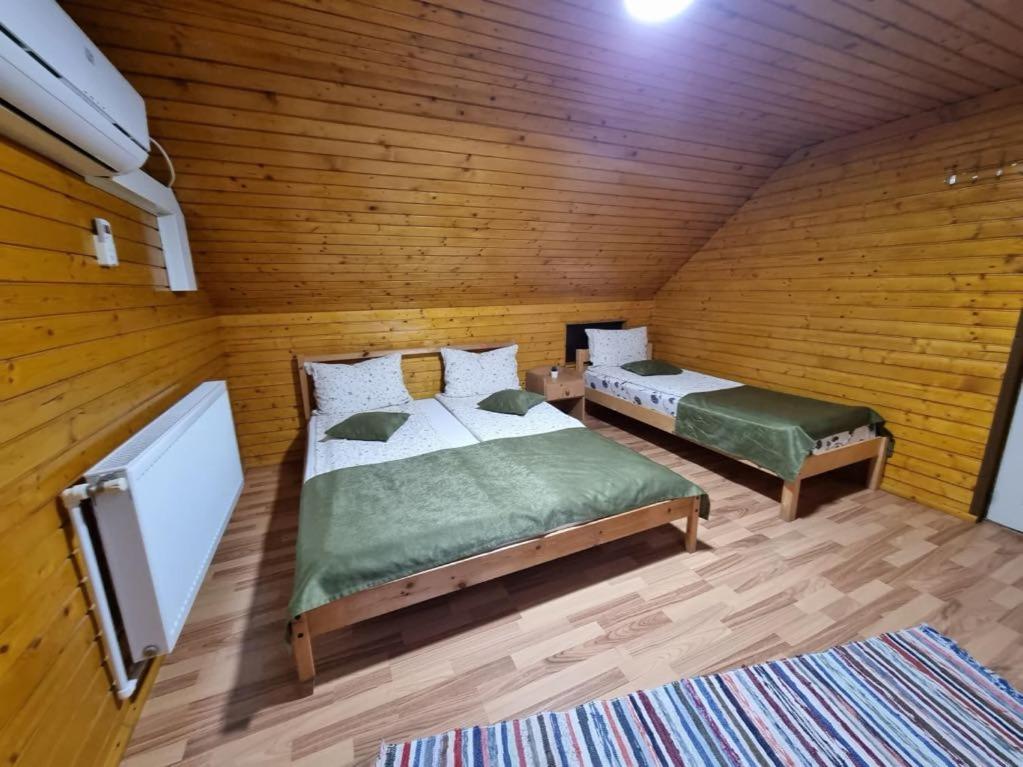 een slaapkamer met twee bedden en een flatscreen-tv bij Kincses Panzió in Praid