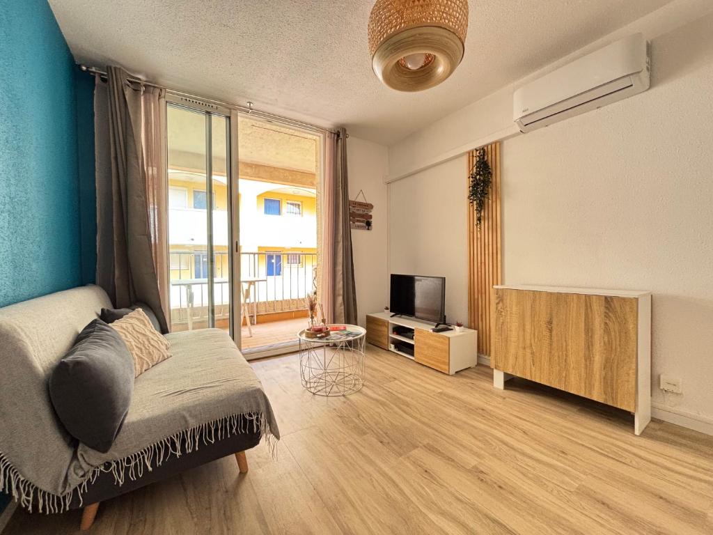 Cette chambre comprend un lit, une télévision et une fenêtre. dans l'établissement Appartement Gruissan climatisation et piscine, à Gruissan