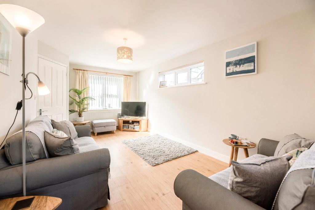 a living room with two couches and a tv at Albert Terrace, Reydon in Reydon