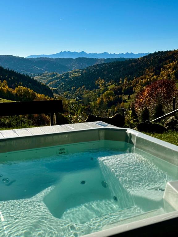 a hot tub with a view of the mountains at Bacówki Resort in Ochotnica Górna