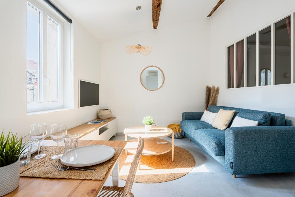 un salon avec un canapé bleu et une table dans l'établissement Nistoun par Dodo à Cassis, à Cassis