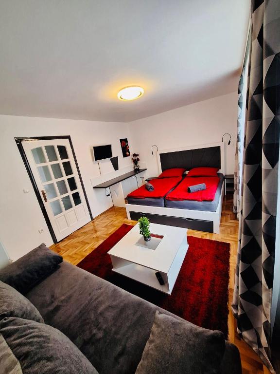 a living room with a couch and a bed at Iskolakert Apartman in Sárospatak