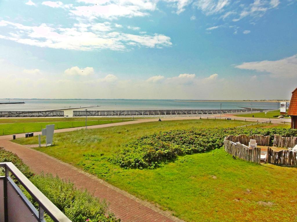 Blick auf den Strand mit einem Pier in der Ferne in der Unterkunft Studio mit Meerblick auf die Robbenbänke von Norderney, geschützter Südwestbalkon in Baltrum