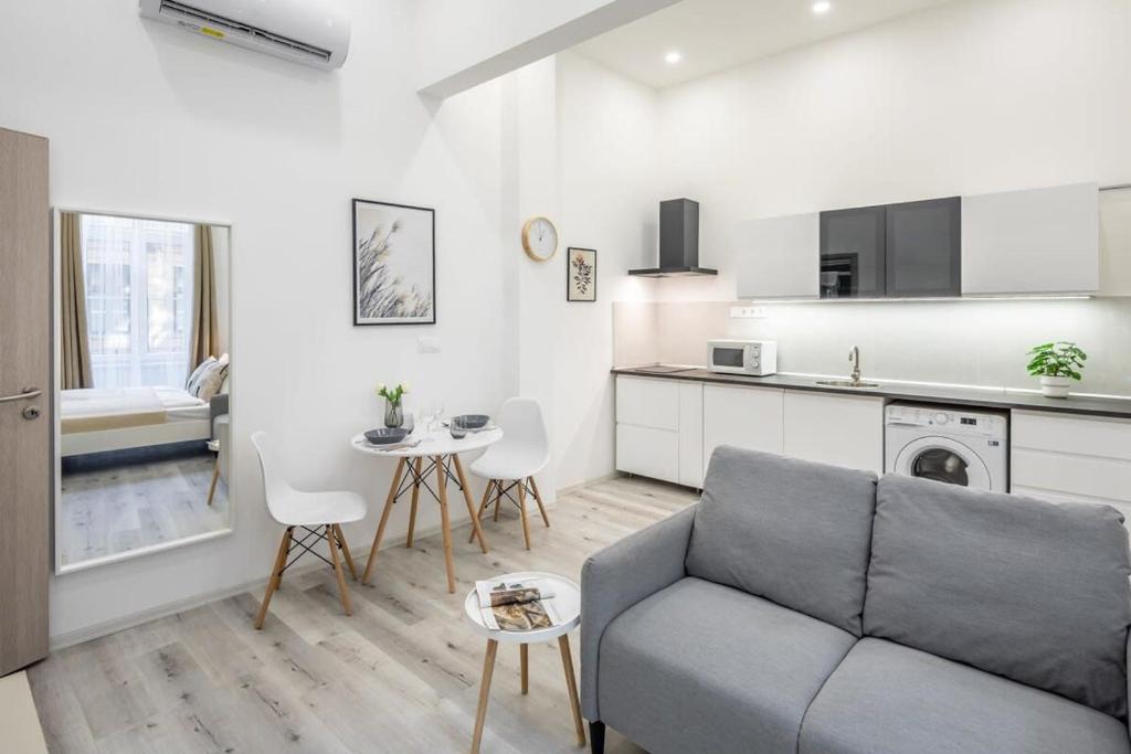 Una sala de estar con un sofá y una cocina. en New Studio Top Location, en Budapest