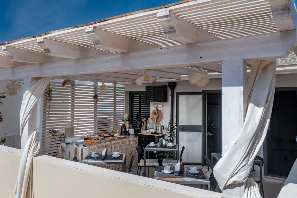 an outdoor patio with a wooden pergola at Dea's Rooms in Noto